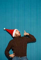 Image showing Surprised christmas man wearing a santa hat