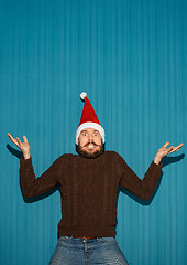 Image showing Surprised christmas man wearing a santa hat