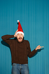 Image showing Surprised christmas man wearing a santa hat