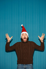 Image showing Surprised christmas man wearing a santa hat