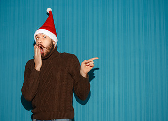 Image showing Surprised christmas man wearing a santa hat