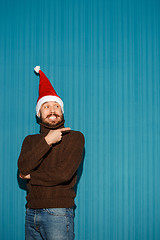 Image showing Smiling christmas man wearing a santa hat