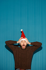 Image showing Surprised christmas man wearing a santa hat