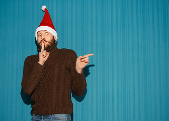 Image showing Surprised christmas man wearing a santa hat