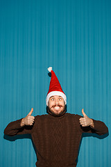 Image showing Smiling christmas man wearing a santa hat