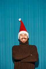 Image showing Smiling christmas man wearing a santa hat