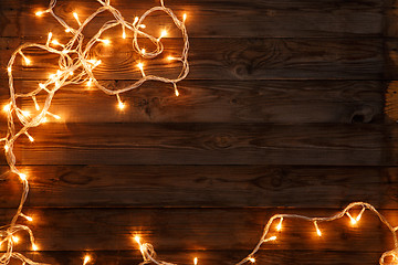 Image showing Christmas and new year dark brown wooden background decorated lightbulbs