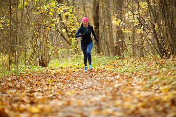 Image showing Sportswoman in sportswear running autumn