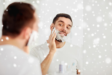 Image showing happy man applying shaving foam at bathroom mirror