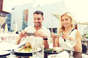 Image showing happy couple with smatphone photographing food