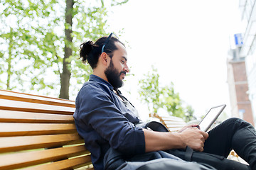 Image showing man with tablet pc sitting on city street bench