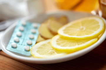 Image showing lemon slices, pills and ginger on plate