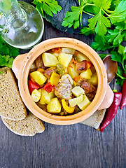 Image showing Roast meat and vegetables in clay pot on board top