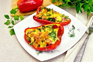 Image showing Pepper stuffed with sausage and cheese in white plate on granite