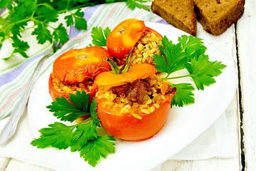 Image showing Tomatoes stuffed with bulgur and meat in plate on light board