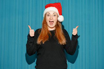 Image showing Surprised christmas girl wearing a santa hat