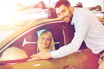 Image showing happy couple buying car in auto show or salon