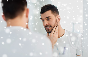 Image showing happy young man looking to mirror at home bathroom