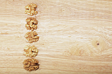 Image showing Row of walnuts on plank