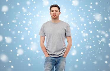 Image showing young man in gray t-shirt and jeans over snow