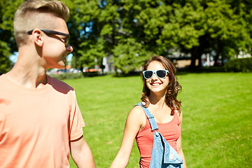 Image showing happy teenage couple walking at summer park