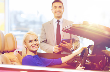 Image showing happy woman with car dealer in auto show or salon