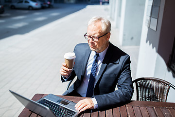 Image showing senior businessman with laptop drinking coffee