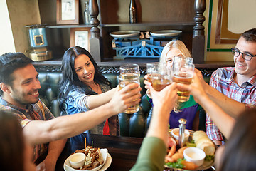 Image showing happy friends drinking beer at bar or pub