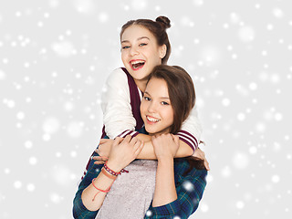 Image showing happy smiling teenage girls hugging over snow