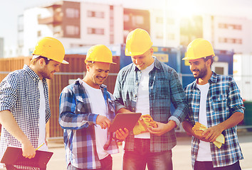 Image showing group of smiling builders with tablet pc outdoors