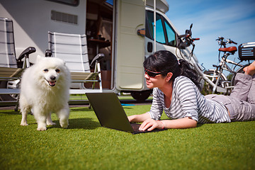 Image showing Woman on the grass with a dog looking at a laptop