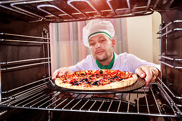 Image showing Chef cooking pizza in the oven.