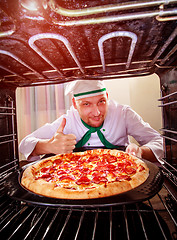 Image showing Chef cooking pizza in the oven.