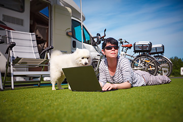 Image showing Woman on the grass with a dog looking at a laptop