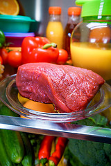 Image showing Fresh raw meat on a shelf open refrigerator