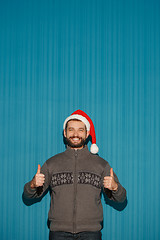 Image showing Smiling christmas man wearing a santa hat