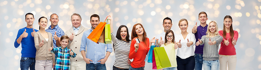 Image showing happy people with shopping bags showing thumbs up