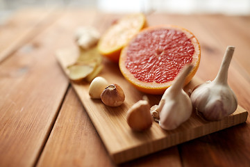 Image showing garlic and grapefruit on wooden board