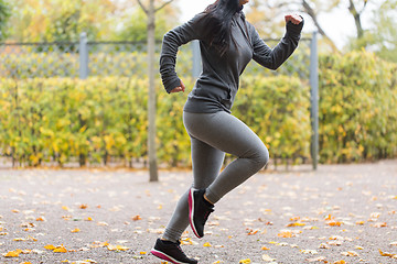 Image showing close up of young woman running in autumn park