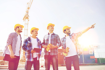 Image showing group of smiling builders with tablet pc outdoors