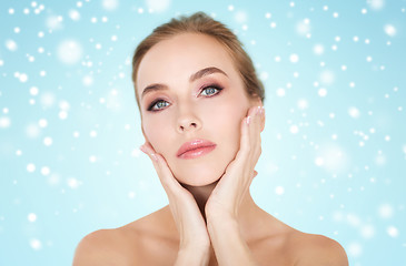 Image showing beautiful woman touching her face over snow