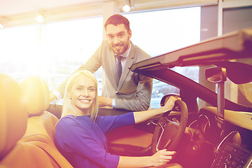 Image showing happy couple buying car in auto show or salon
