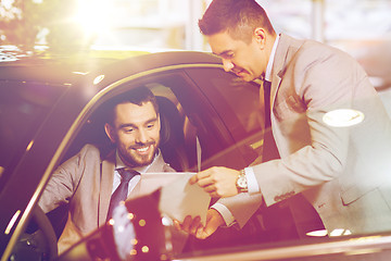 Image showing happy man with car dealer in auto show or salon