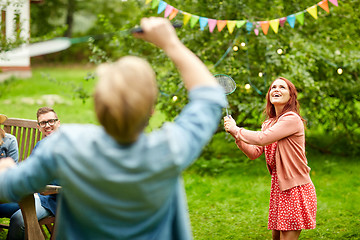 Image showing happy friends playing badminton at summer garden