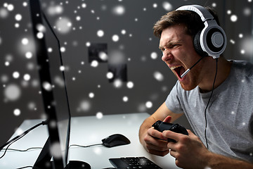 Image showing man in headset playing computer video game at home