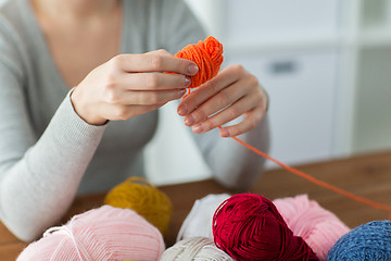 Image showing woman pulling yarn up into ball