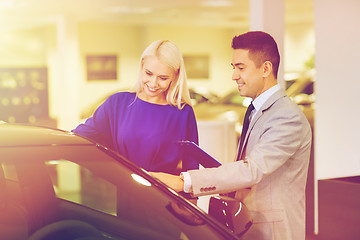 Image showing happy woman with car dealer in auto show or salon