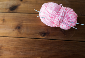 Image showing knitting needles and ball of pink yarn on wood