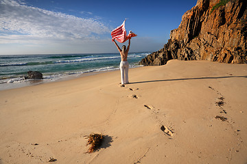 Image showing A woman walks along the beach, travel, health and wellbeing