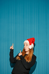 Image showing Surprised christmas girl wearing a santa hat